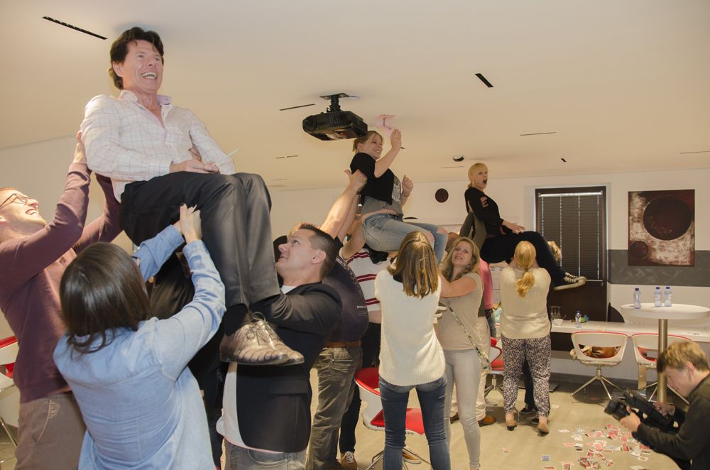 Deelnemers tillen iemand in de lucht tijdens de teambuilding met behulp van ideomotorische krachten (Carpenter effect).
