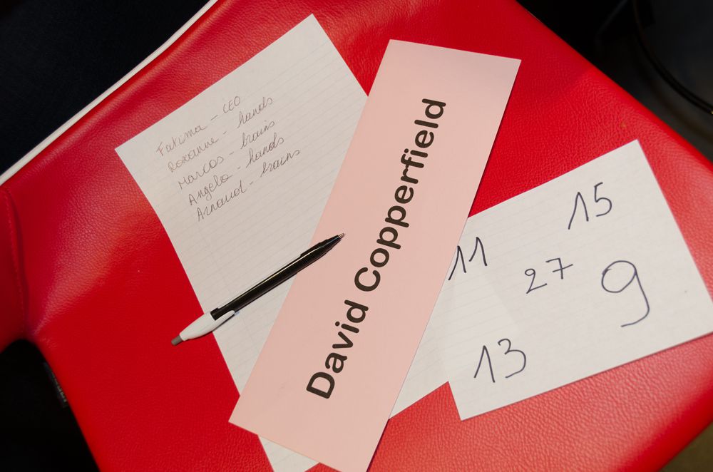 Een tafel met daarop een lijstje van namen uit een team en de naam van goochelaar David Copperfield tijdens een teambuilding evenement.
