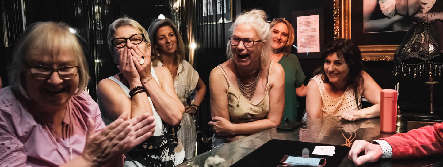 Des femmes souriantes s'amusent pendant le spectacle du magicien Tony Price.