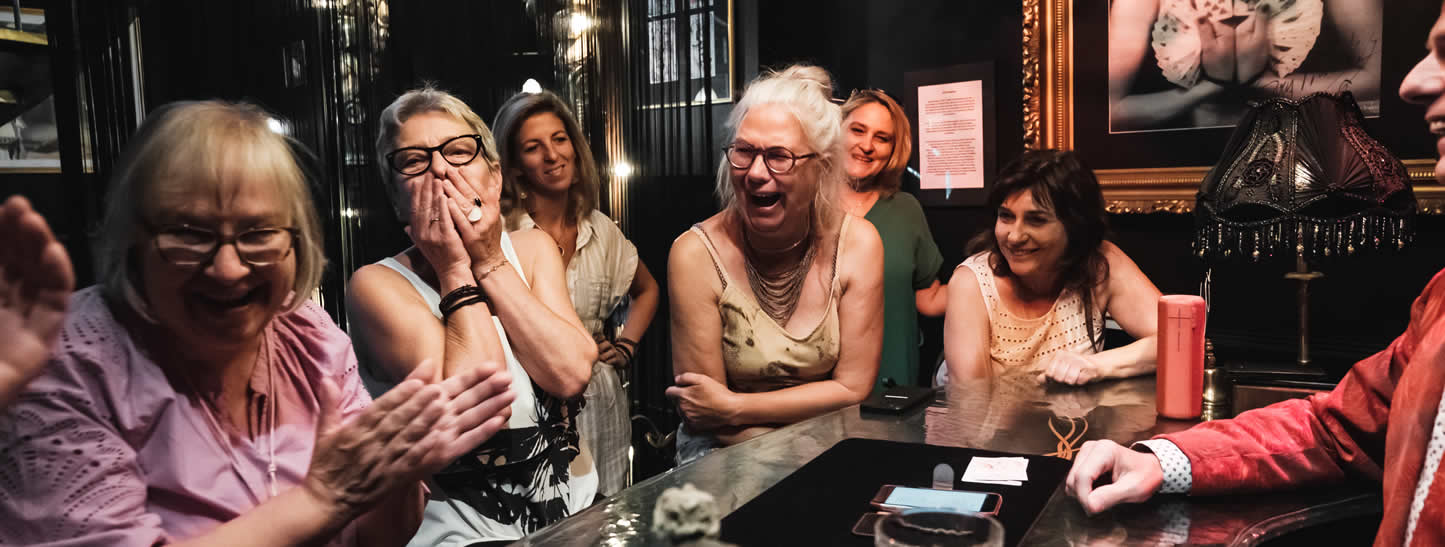 Lachende dames hebben plezier tijdens optreden van Goochelaar Tony Price.